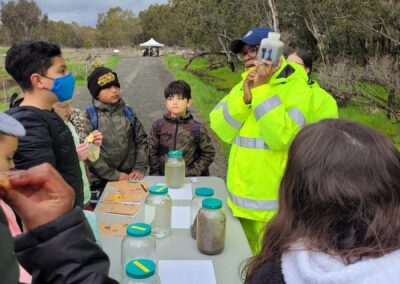 kids around a table with woman holding water jug