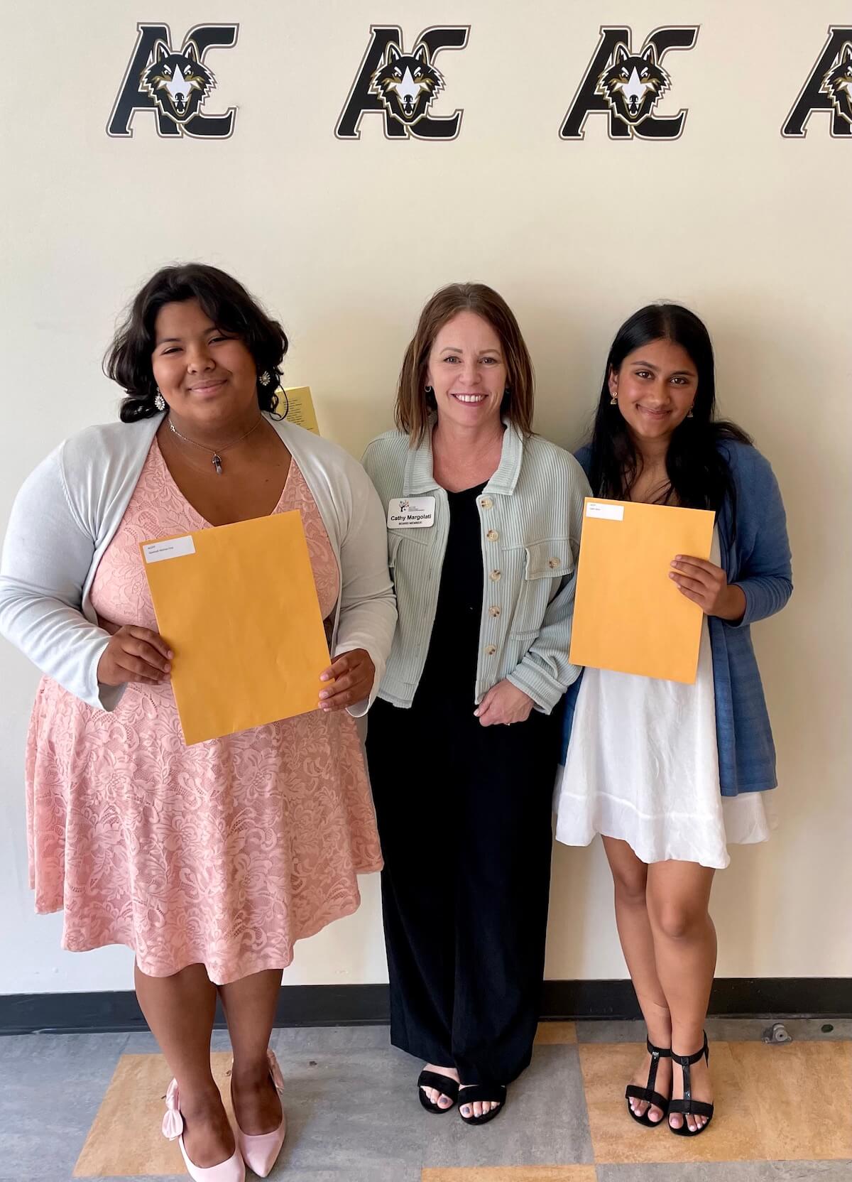 high school students with scholarship smiling