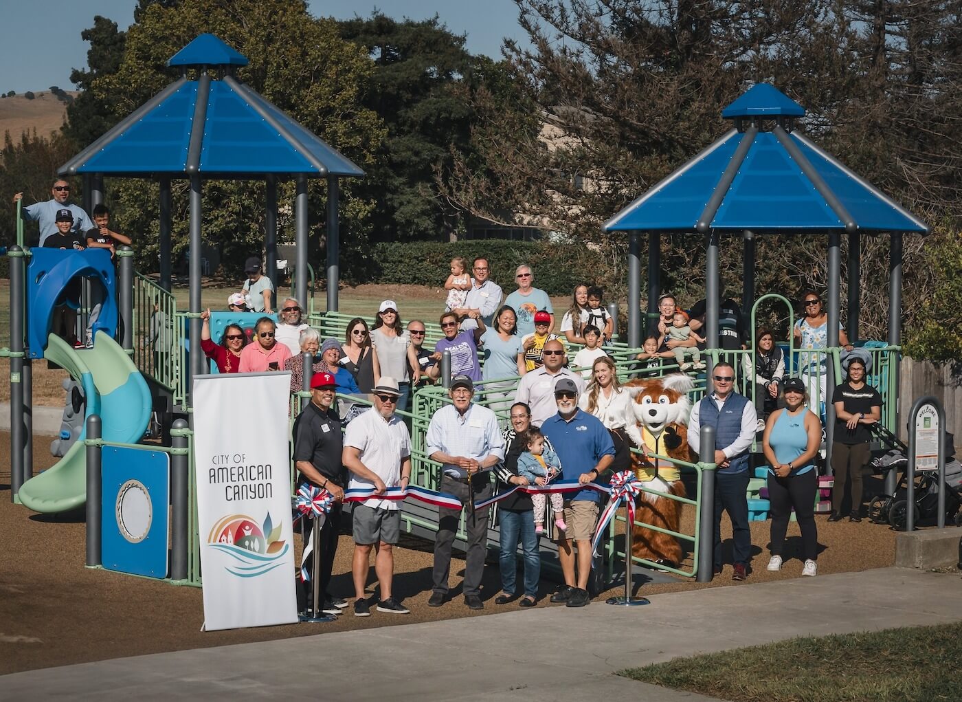 people standing in the park doing a ribbon cutting