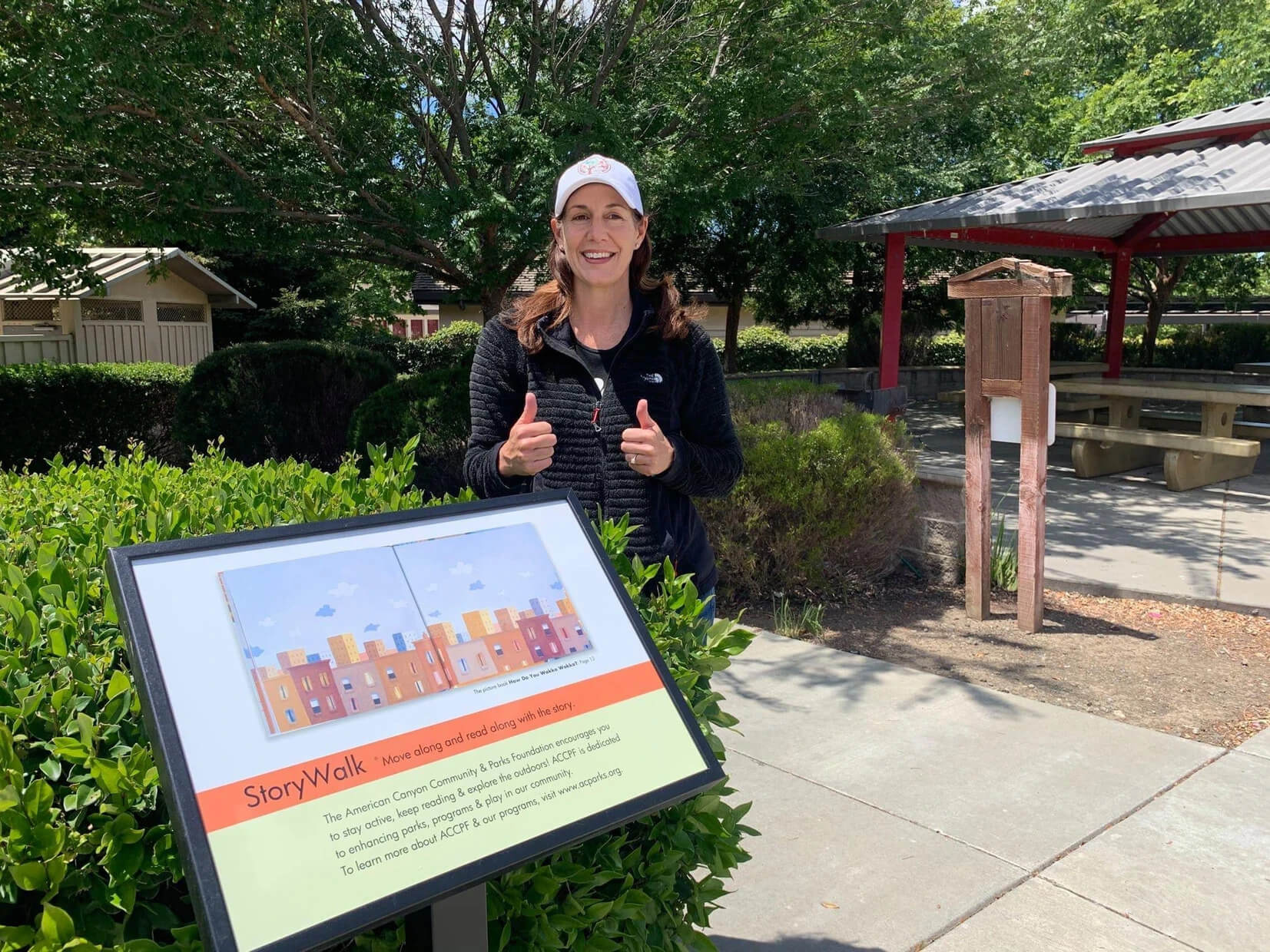 ACCPF executive director giving two thumbs up for the new story walk kiosks