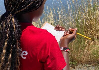 girl writing on notebook in nature
