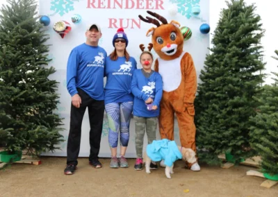 people smiling with reindeer (person in costume)