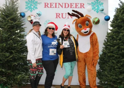 people smiling with reindeer (person in costume)