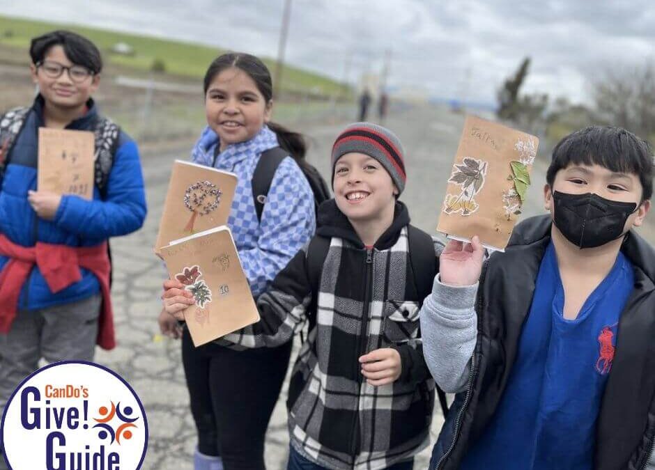Kids at the wetlands with their nature journals and the give guide logo
