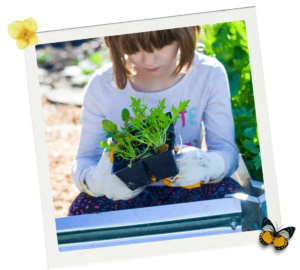 young girl holding plants to put into a garden