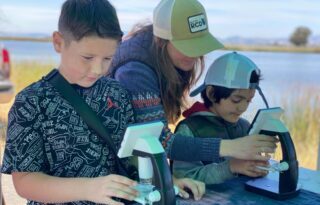Two 4th graders look at plankton in a microscope